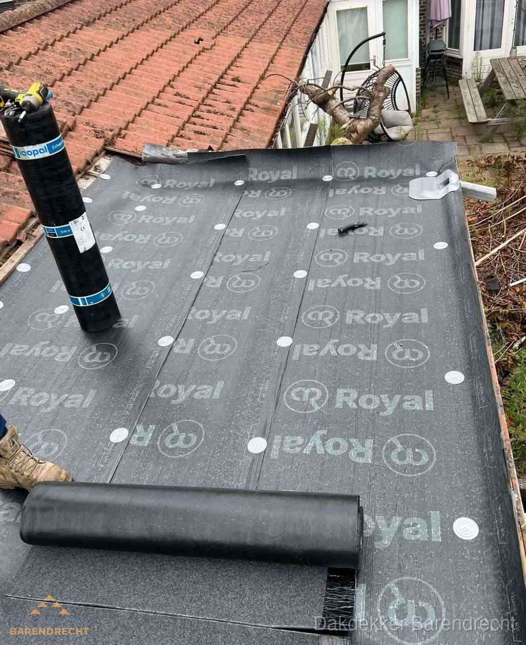 Plat dak met nieuwe bitumen dakbedekking en brandgereedschap in Barendrecht