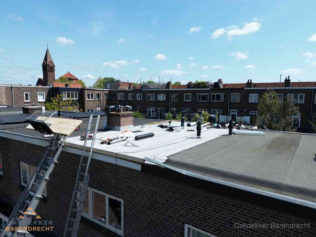 Dakdekkers aan het werk op plat dak in Barendrecht