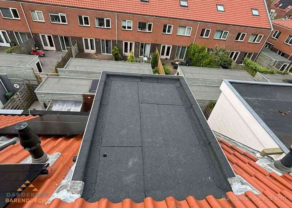 Plat dak met bitumen bedekking naast dakkapel in Barendrecht