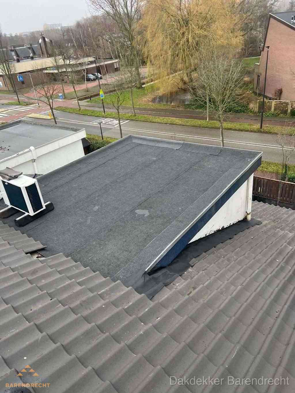 Plat dak met bitumen dakbedekking naast schuin pannendak in Barendrecht